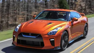 Pomarańczowy Nissan GT-R pędzi po drodze. Sprawdź, jaka jest jego nissan gtr cena i osiągi.