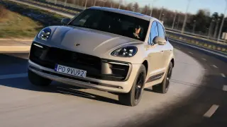 Beżowy Porsche Macan GTS pędzi po drodze, kierowca w okularach obserwuje trasę.