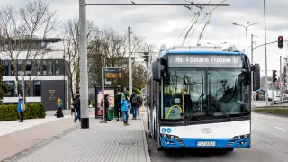 Nowoczesne trolejbusy w Polsce, jak ten Solaris Trollino 12, czekają na pasażerów na przystanku.