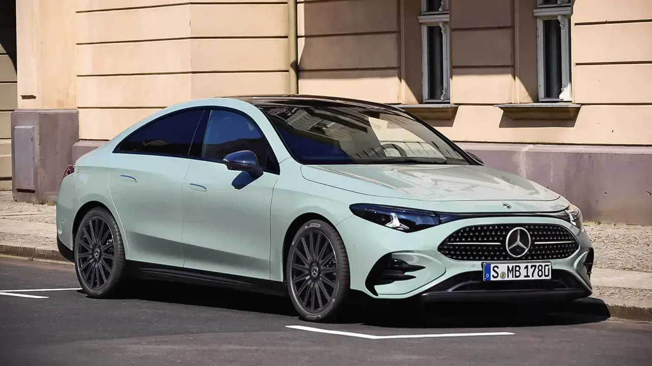 Jasnoszary Mercedes CLA 180 z czarnym dachem stoi na ulicy przed kamienicą.