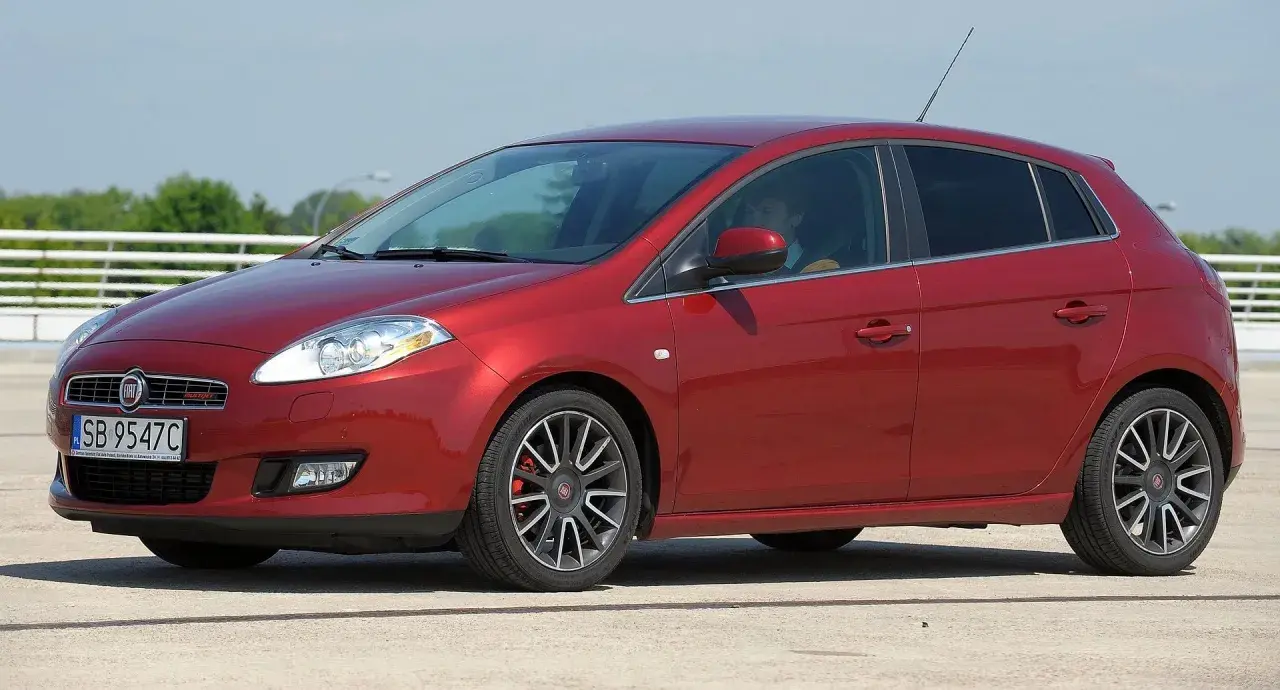 Czerwony Fiat Bravo 1.4 T-Jet z przyciemnianymi szybami i felgami.