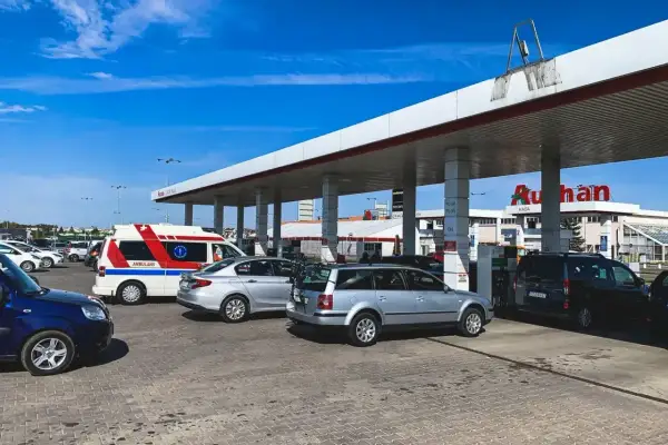 Stacja paliw Auchan. Samochody, w tym karetka, tankują pod zadaszeniem. Sprawdzamy auchan ceny paliw.