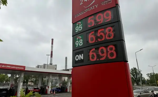 Cena paliwa w Warszawie: Pb 95 za 5.99, Pb 98 za 6.58, ON za 6.98. Stacja paliw z kominami w tle.