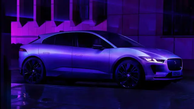 Elegancki jaguar elektryczny lśni w fioletowym świetle, gotowy na nocną jazdę.